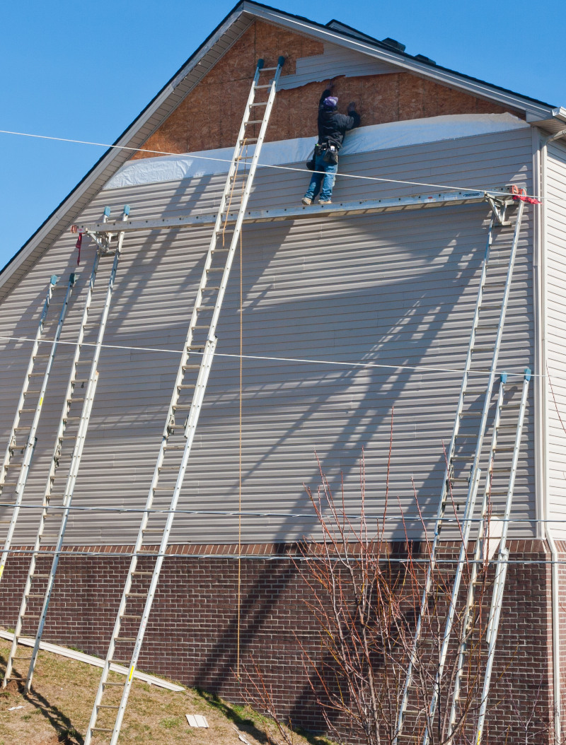 Worker fixing damaged siding