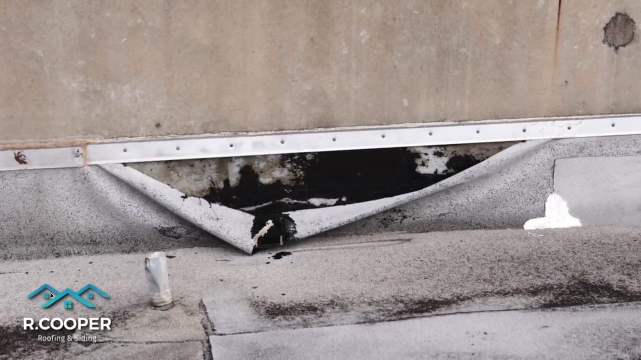 Failed flat roof membrane peeling, a sign a TPO roof needs repair